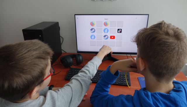 chłopcy rozwiązują zadanie na komputerze