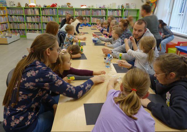 zdjęcie uczestnikó warsztatów siedzących przy połączonych stołach