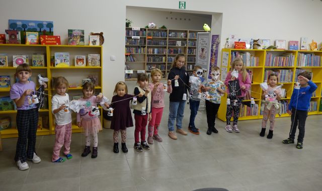 dzieci stoją w rzędzie i pokazują wykonane przez siebie duszki