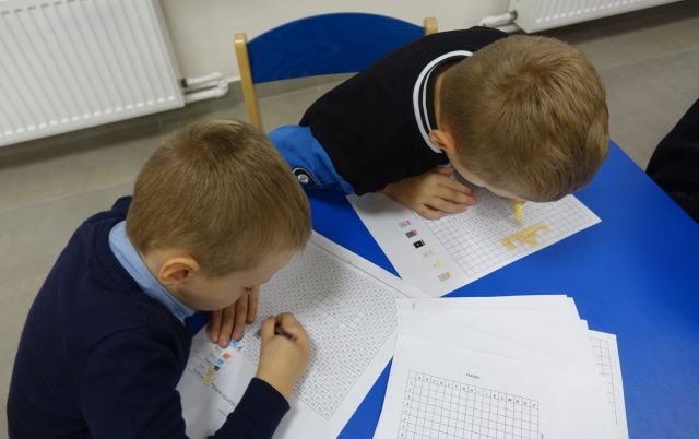 dzieci rozwiązują zadania na kartkach