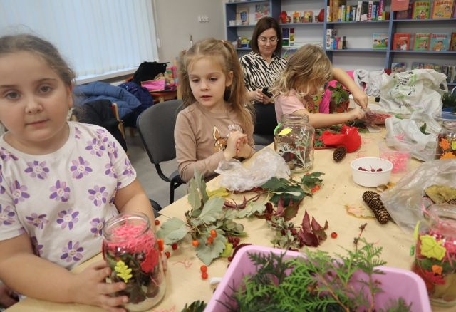 dzieci ukłądają dary jesieni w słoikach