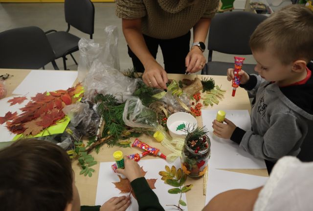 kobieta ukłąda gałązki i inne dary jesieni