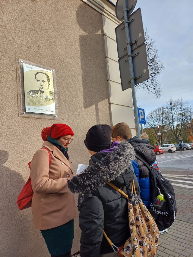 młodzież przed budynkiem z tablicą Fiszera