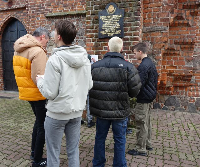 młodzież przed budynkiem z czerwonej cegły