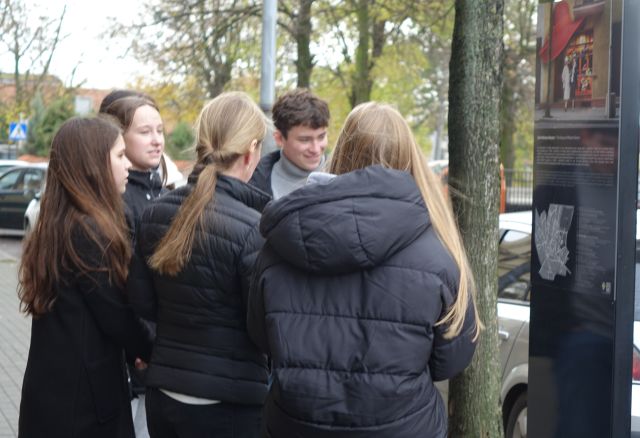 młodzież rozwiązująca zagadki w queście w przestrzeni miejskiej