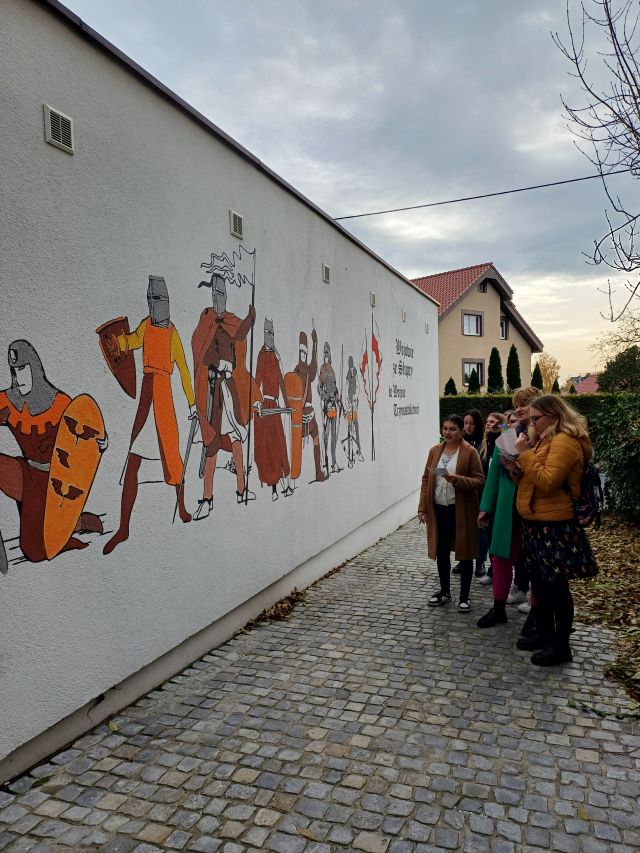 młodzież przed muralem rycerzy
