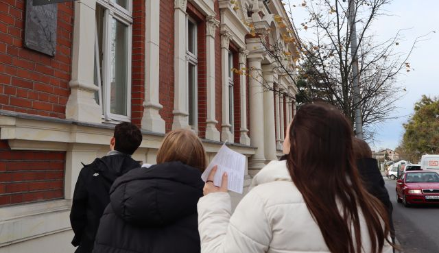 młodzież przed budynkiem z filarami