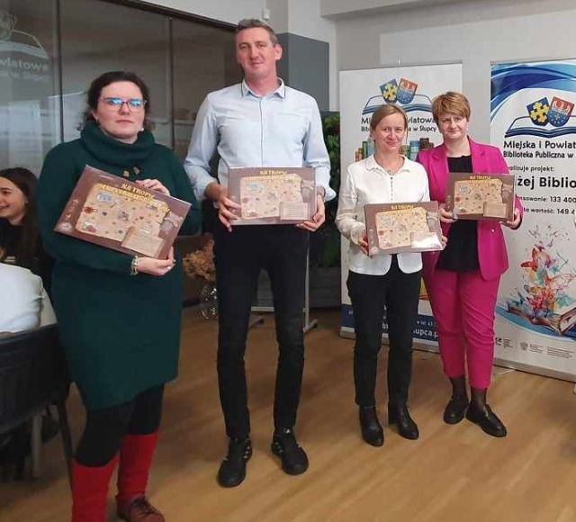 4 nauczycieli pozuje do zdjęcia z grami planszowymi