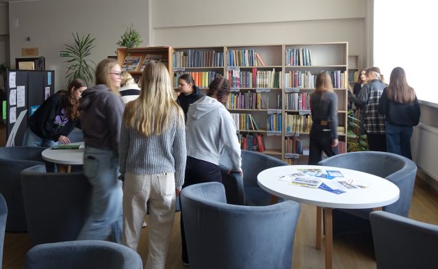 młodzież szuka ukrytych kopert w czytelni biblioteki