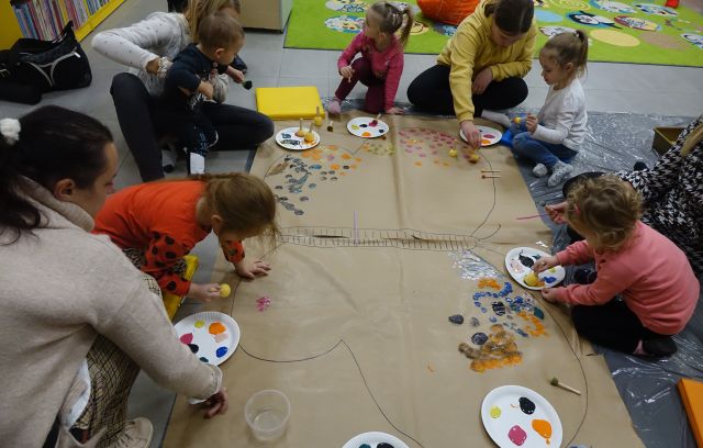 dzieci i rodzice kolorują kropkami farby motyla