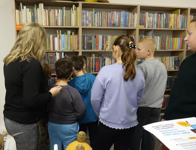 dzieci przed regałem z książkami