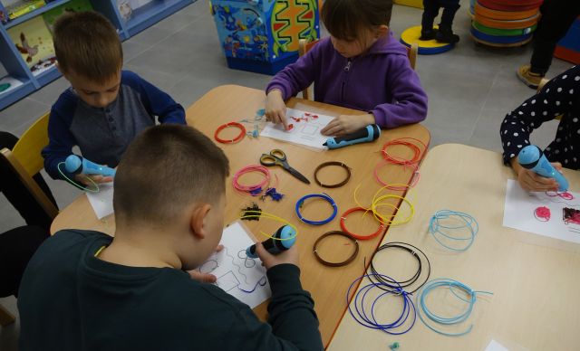 dzieci drukują długopisami 3D figury geometryczne