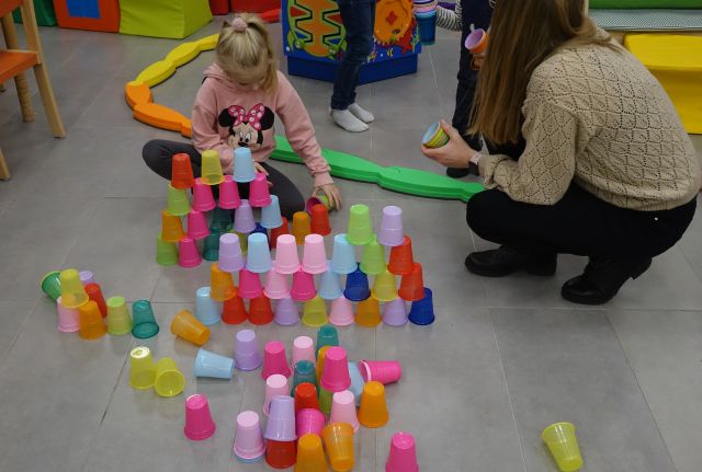 dzieci kodują (układają piramidę) przy użyciu kolorowych kubeczków