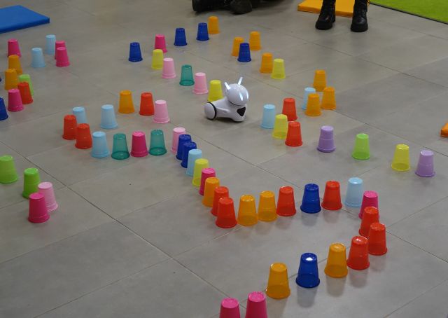 robot Photon jeździ pomiędzy kolorowymi kubeczkami