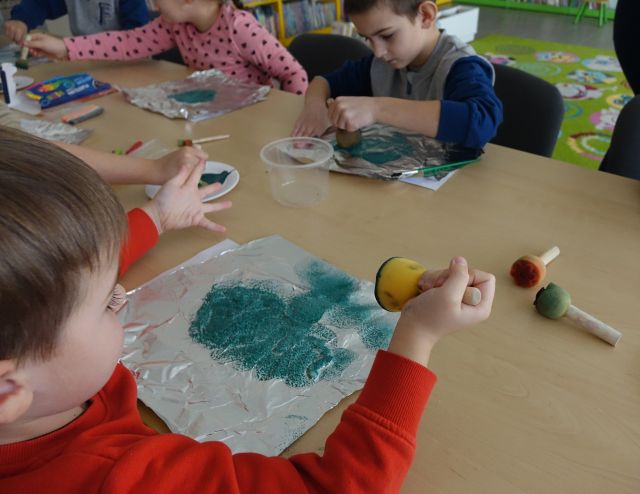 dzieci pacają farbą na folii aluminiowej