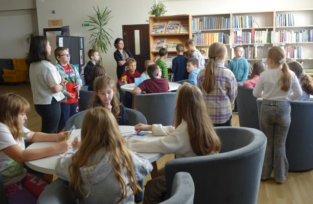 uczniowie oglądajaą czytelnię biblioteki