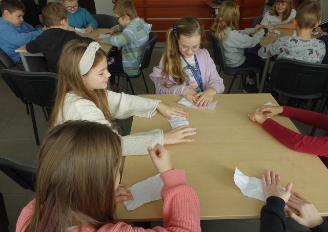 uczniowie zaginają gniotą kartki papieru