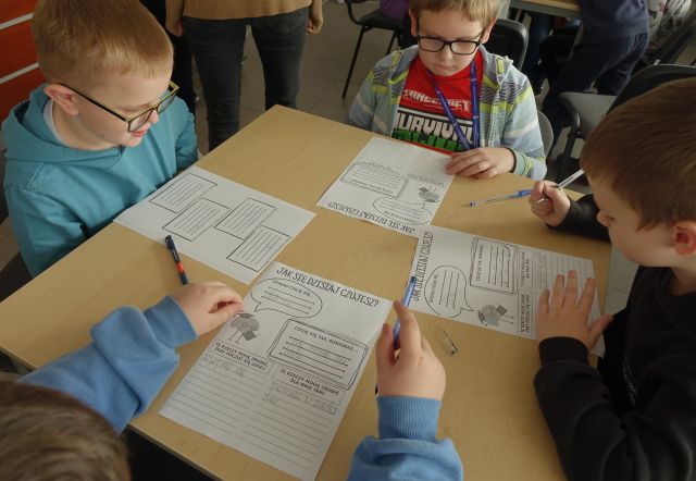 dzieci wykonują zadania na kartkach