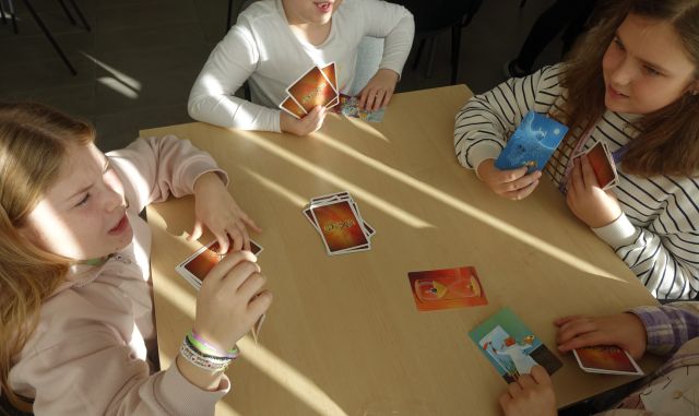 uczniowie grają w grę planszową