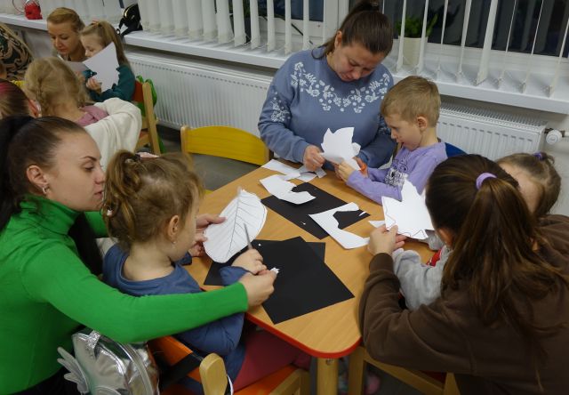 dzieci i rodzice wycinają liście z kartek