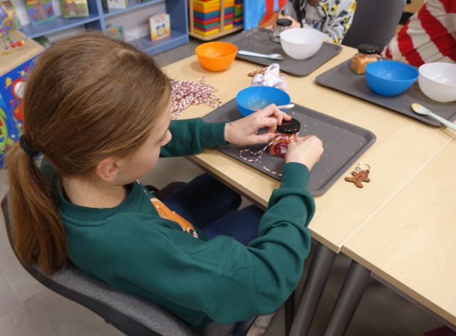 dziewczynka zawiązuje sznurek na słoiczku z solą do kąpieli