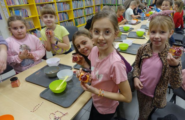 dziewczynki pokazują wykonaną przez siebie sól do kąpieli wsypaną do słoiczków