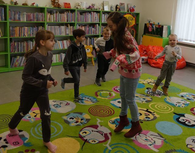 5 dzieci tańczy na kolorowym dywanie