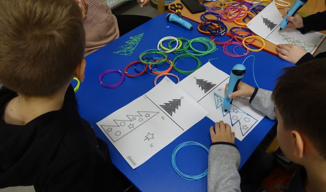 dzieci przy użyciu długopisów 3D tworzą choinki