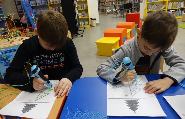 dzieci przy użyciu długopisów 3D tworzą choinki