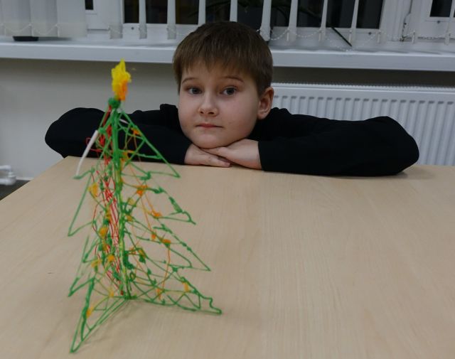chłopiec prezentuje wykonaną przez siebie długopisem 3D choinkę