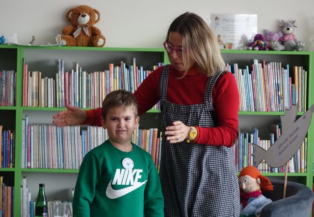 autorka książek z chłopcem, w tle regały z książkami