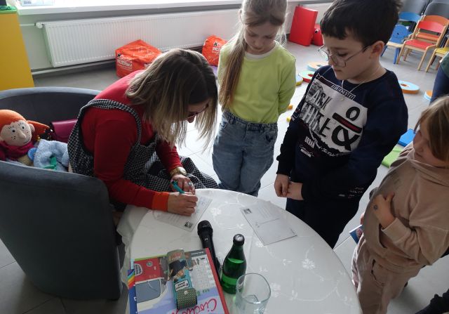 autorka podpisuje się dzieciom na pocztówkach