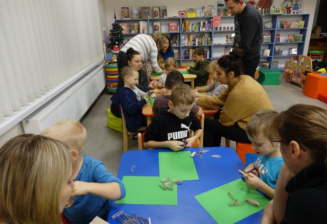 dzieci malują na kartkach siedząc przy stolikach