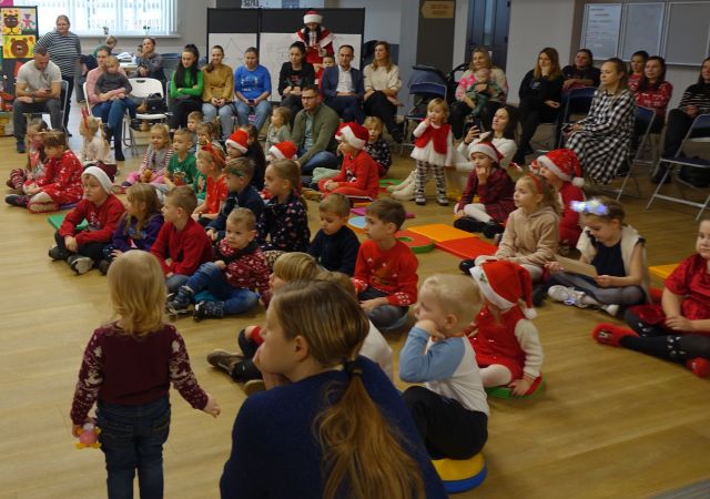 dzieci zgromadzone na spotkaniu z Mikołąjem siedzą na kolorowych pufach