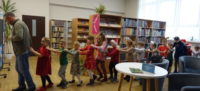 uczestnicy spotkania z Mikołajem bawią się w pociąg