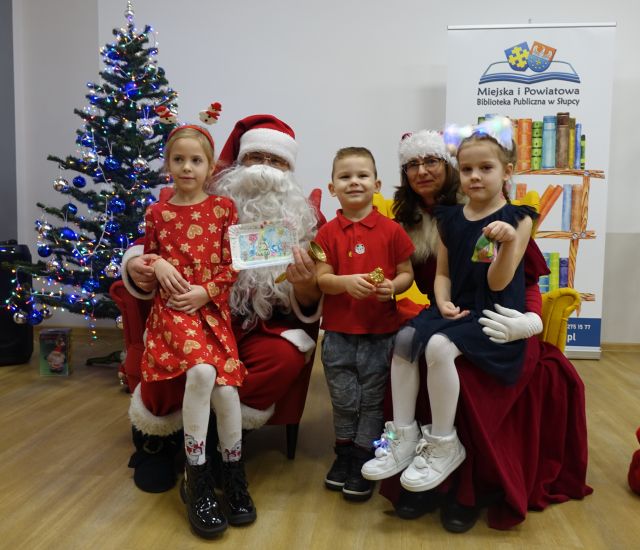 dwie dziewczynki i chłopiec pozują do zdjęcia z Mikołajem i Mikołajową