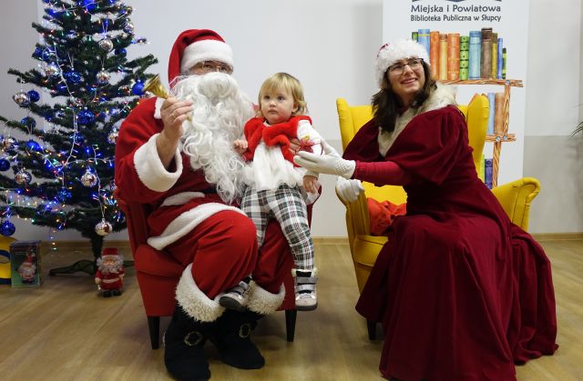małą dziewczynka pozuje do zdjęcia z Mikołajem i Mikołąjową