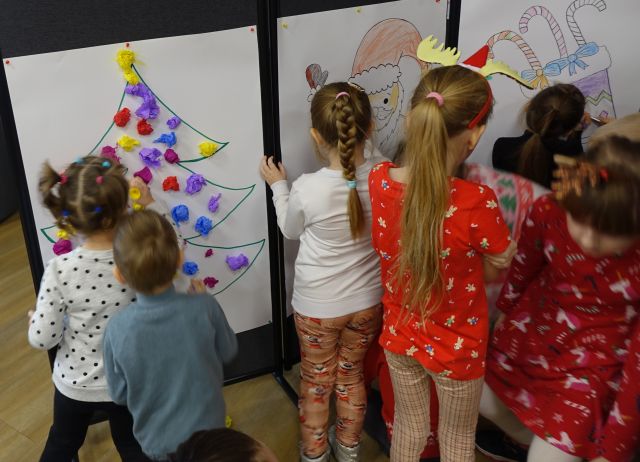 dzieci kolorują dużego Mikołaja i choinkę