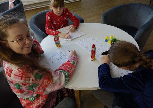 dzieci rozwiązują krzyżówki i kolorują malowanki świąteczne