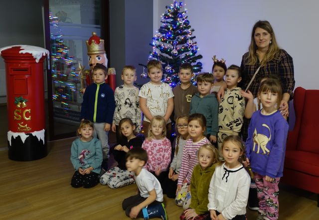 przedszkolaki ze swoją panią pozują do zdjęcia przy choince