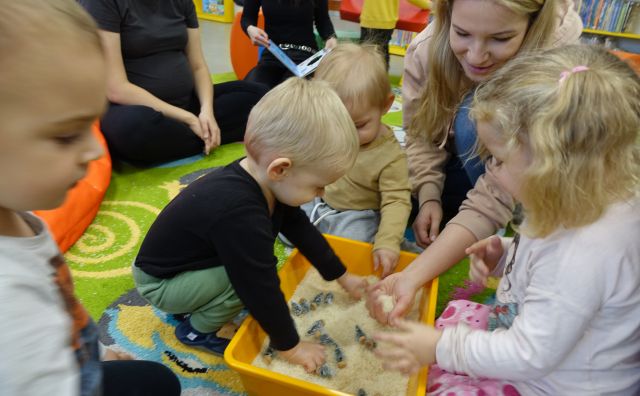 mamusie i małe dzieci bawią się ryżem wsypanym do miski i ukrytymi w nim zwierzątkami