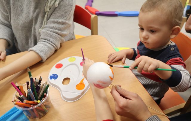 mały chłopiec maluje farbkami styropianową bombkę