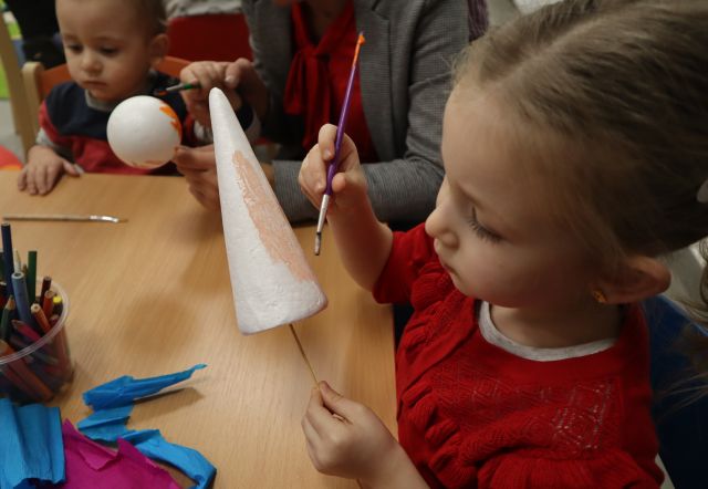 dziewczynka maluje farbkami styropianową bombkę