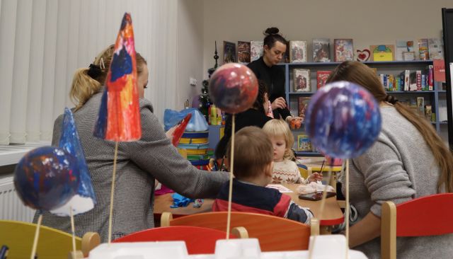 prezentacja bombek styropianowych pomalowanych przez dzieci, w tle malujące dzieci