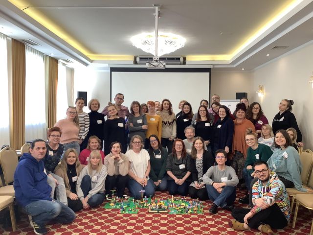 liczna grupa bibliotekarek i bibliotekarzy pozujących do zdjęcia grupowego