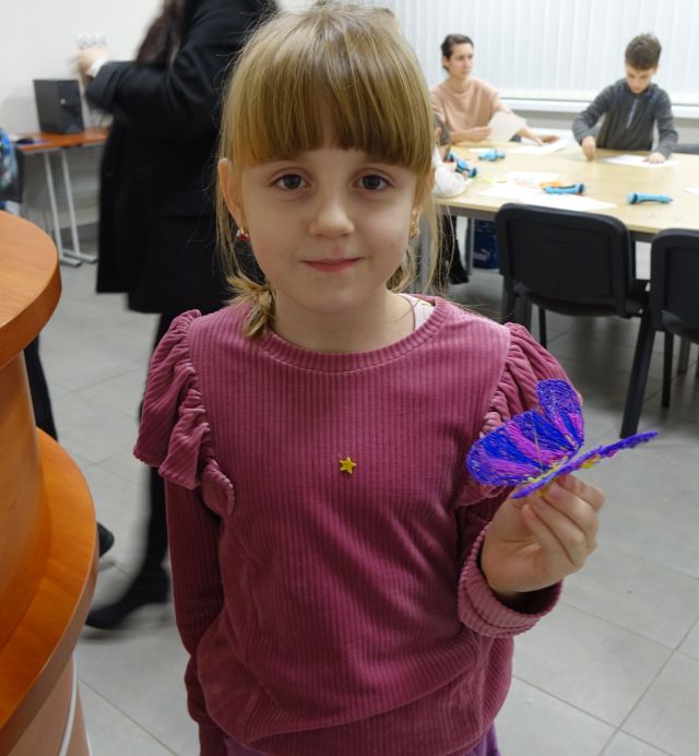 dziewczynka prezentuje motyla wydrukowanego długopisem 3d