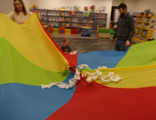 dzieci i rodzice bawią się z kolorową chustą animacyjną