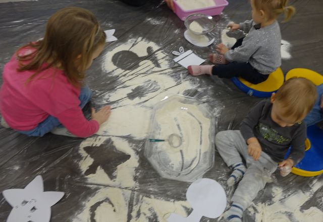 na szarej folii malarskiej wysypane z mąki symbole zimowe