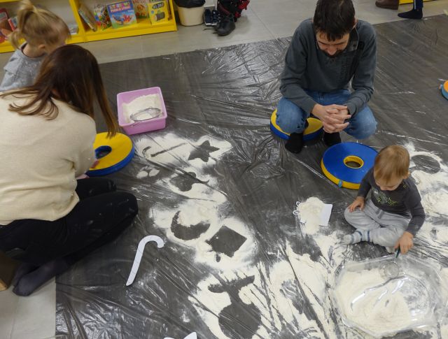 na szarej folii malarskiej wysypane z mąki symbole zimowe