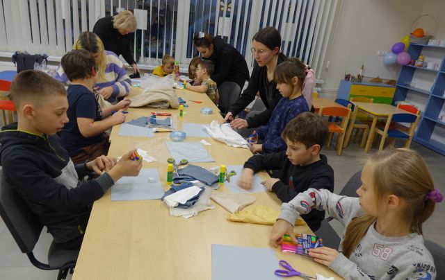 dzieci z rodzicami robią zimowe kolaże z materiałów tekstylnych